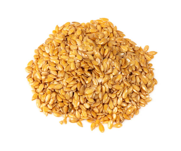 Pile of golden flax seeds closeup on white background