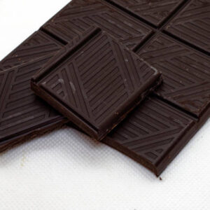 A bar of dark chocolate, opened, cropped against a white background