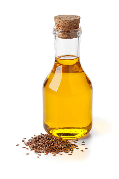 Bottle of flax seed oil ans seeds on white background